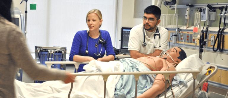 medical students practicing on a mannequin